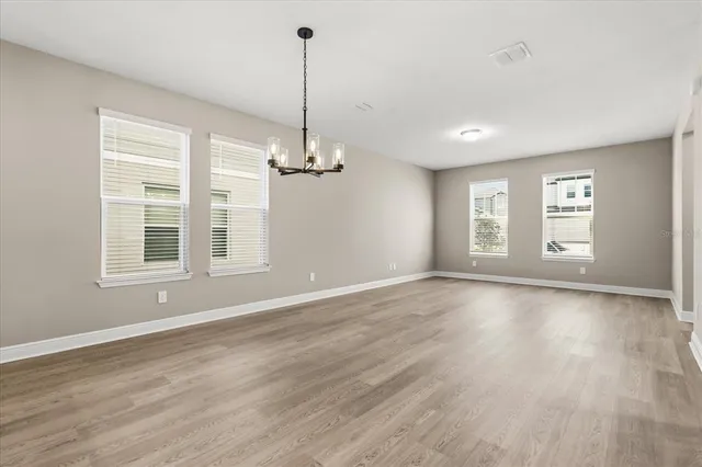 a view of empty room with wooden floor and windows