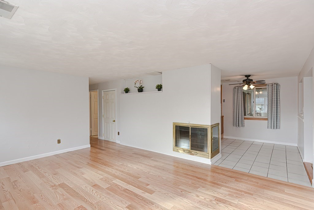 70 Roseen Road Holbrook, MA 02343 - Photo 6 of 35 an empty room with wooden floor and fireplace