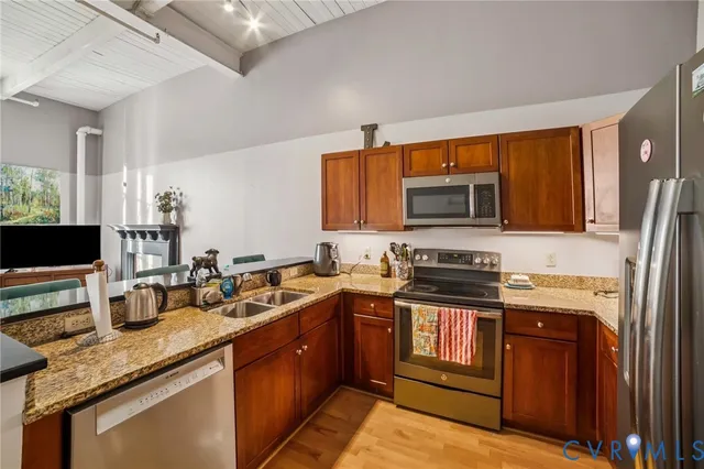 a kitchen with stainless steel appliances granite countertop a sink and refrigerator