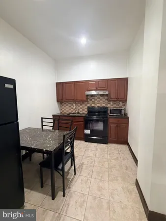 a kitchen with stainless steel appliances a table and chairs in it