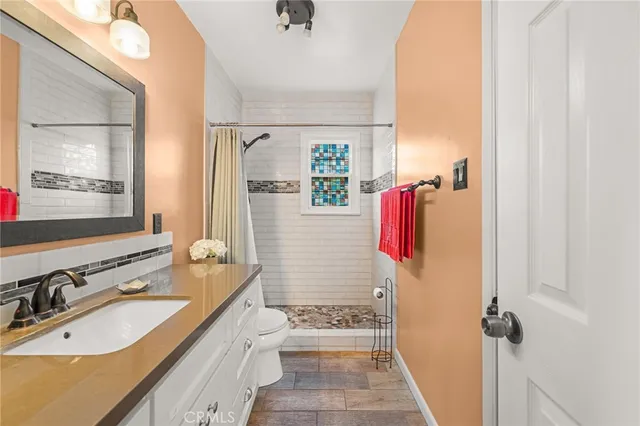 a bathroom with a sink vanity granite tub shower and a mirror