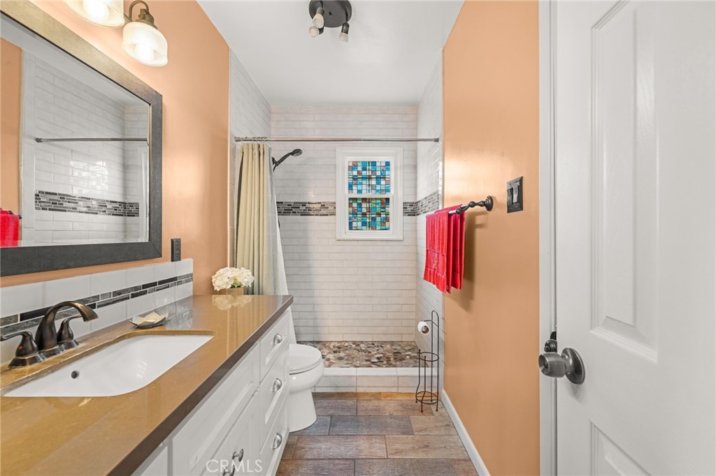 3620 Hoover Street Riverside, CA 92504 - Photo 16 of 44 a bathroom with a sink vanity granite tub shower and a mirror