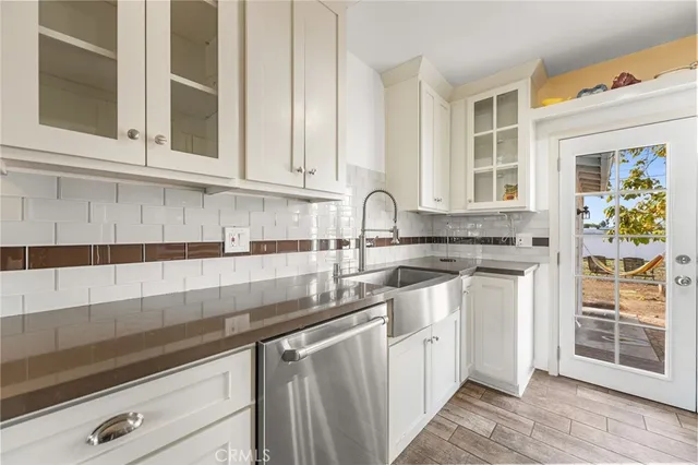 a kitchen with stainless steel appliances granite countertop white cabinets and window