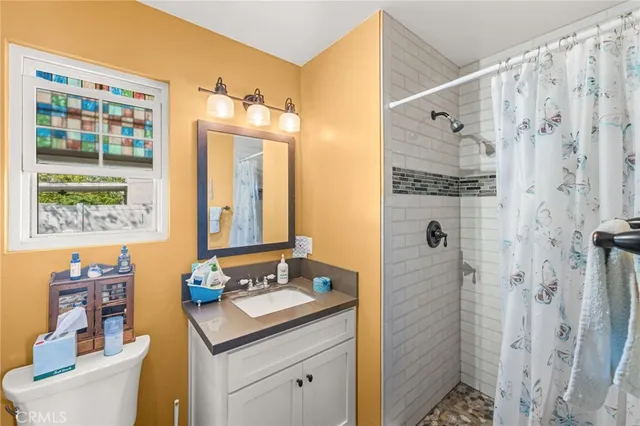 a bathroom with a granite countertop sink toilet and shower