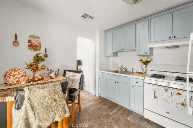 a kitchen with stainless steel appliances kitchen island granite countertop a table chairs in it and white cabinets