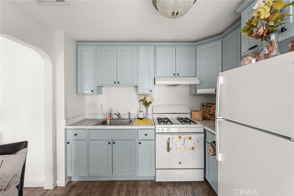 3620 Hoover Street Riverside, CA 92504 - Photo 24 of 44 a kitchen with a sink a stove a refrigerator and white cabinets