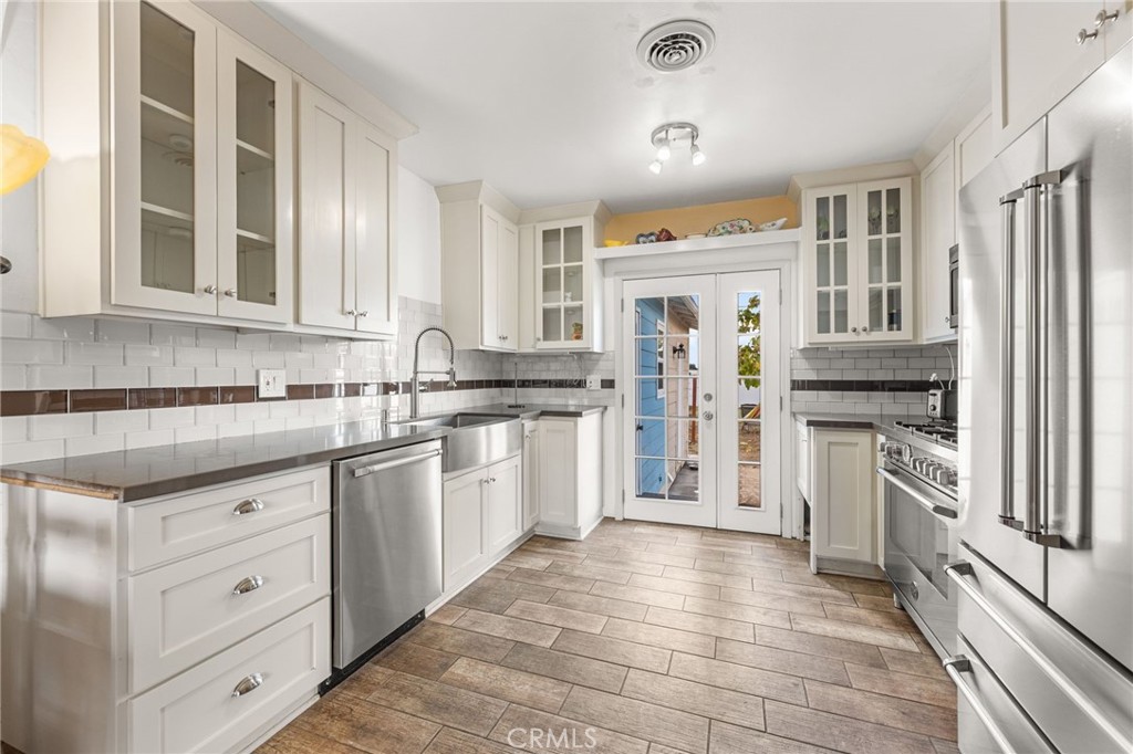 3620 Hoover Street Riverside, CA 92504 - Photo 4 of 44 a kitchen with white cabinets and stainless steel appliances