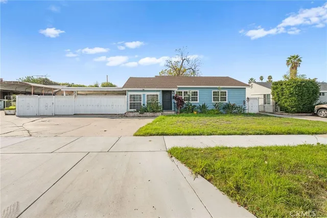 a view of a white house with a yard and potted plants