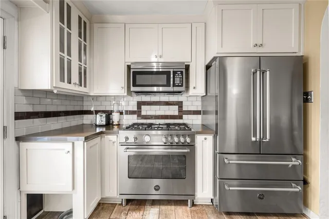 a kitchen with cabinets and stainless steel appliances