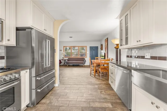 a kitchen with stainless steel appliances granite countertop a refrigerator oven a sink dishwasher and cabinets with wooden floor