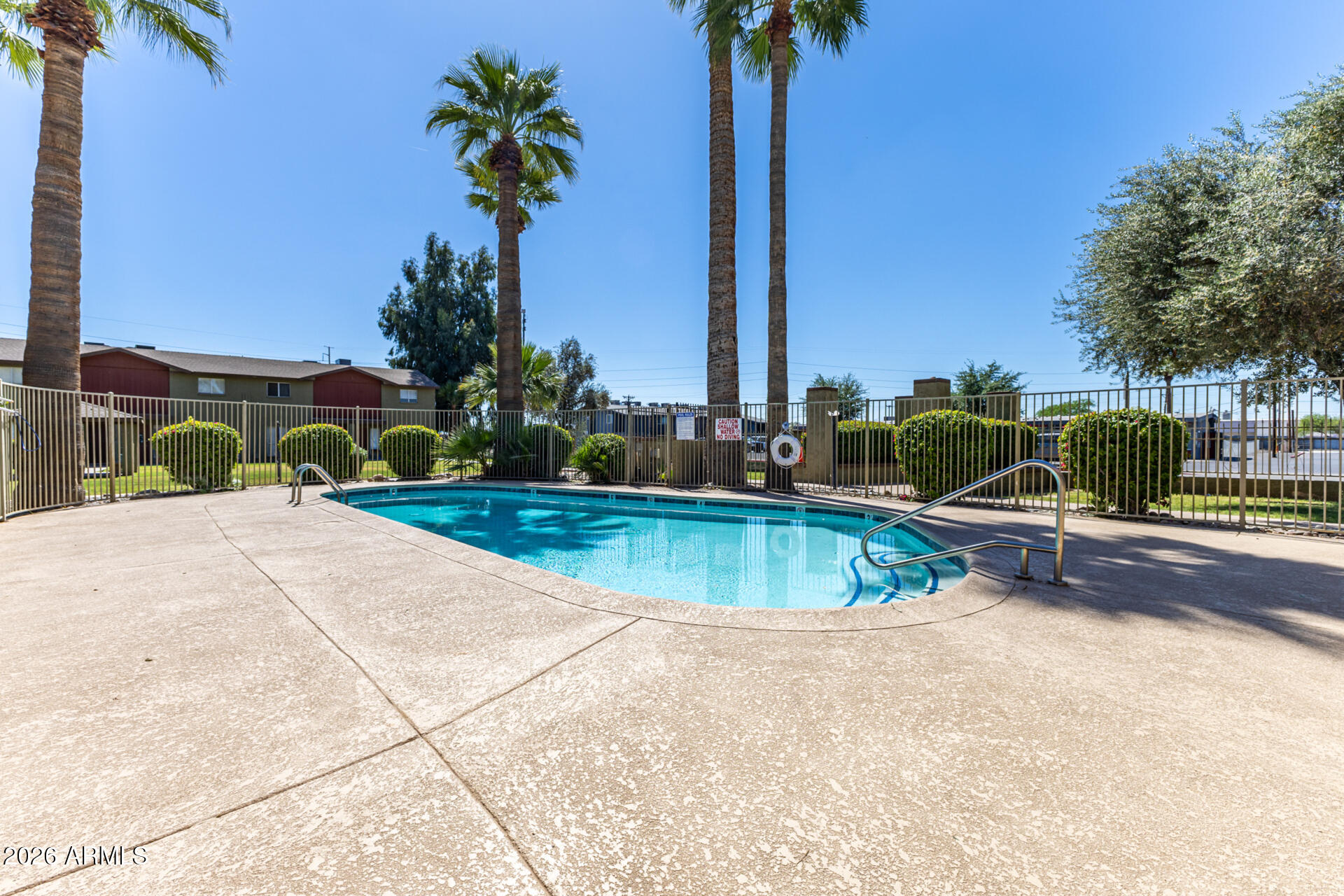 4615 North 39th Avenue, Unit 23 Phoenix, AZ 85019 - Photo 14 of 15 a view of a swimming pool with a yard and palm trees