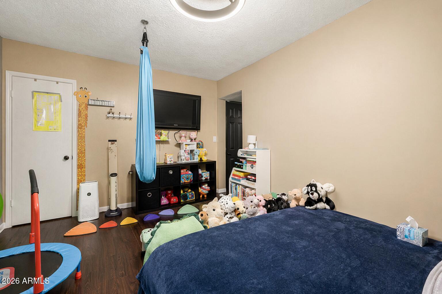 4615 North 39th Avenue, Unit 23 Phoenix, AZ 85019 - Photo 8 of 15 a bedroom with bed and a flat tv screen