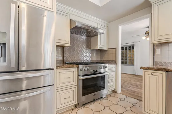a kitchen with granite countertop white cabinets and white appliances