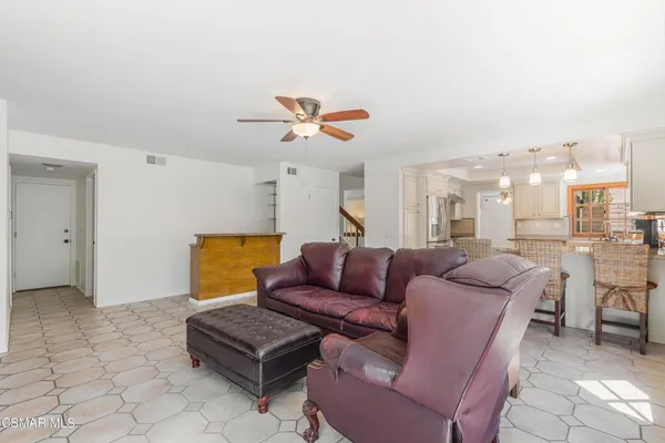 a living room with furniture a rug and white walls