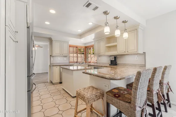 a kitchen with stainless steel appliances granite countertop a sink and a refrigerator