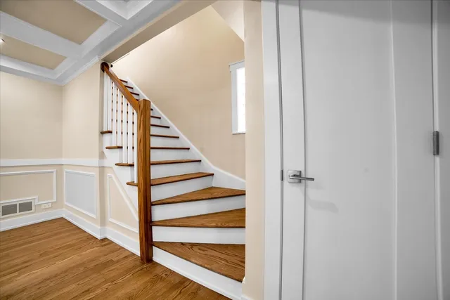 a view of a hallway with wooden floor and entryway