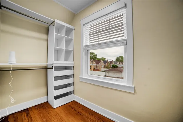 a view of a bedroom with wooden floor and a window