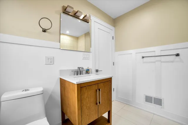 a bathroom with a sink a toilet and a mirror