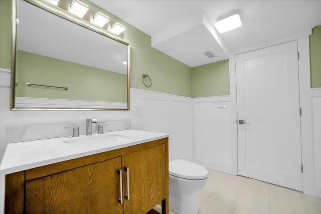 a bathroom with a sink a toilet a mirror and vanity