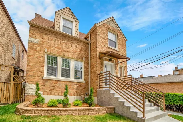 a view of a brick house with a small yard