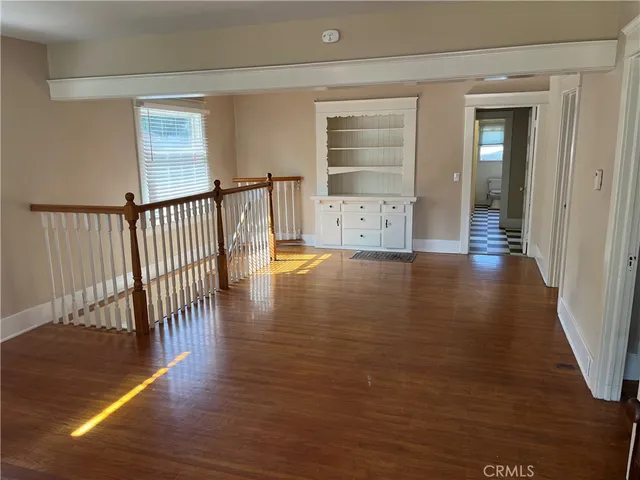 a view of a hallway with wooden floor and stairs