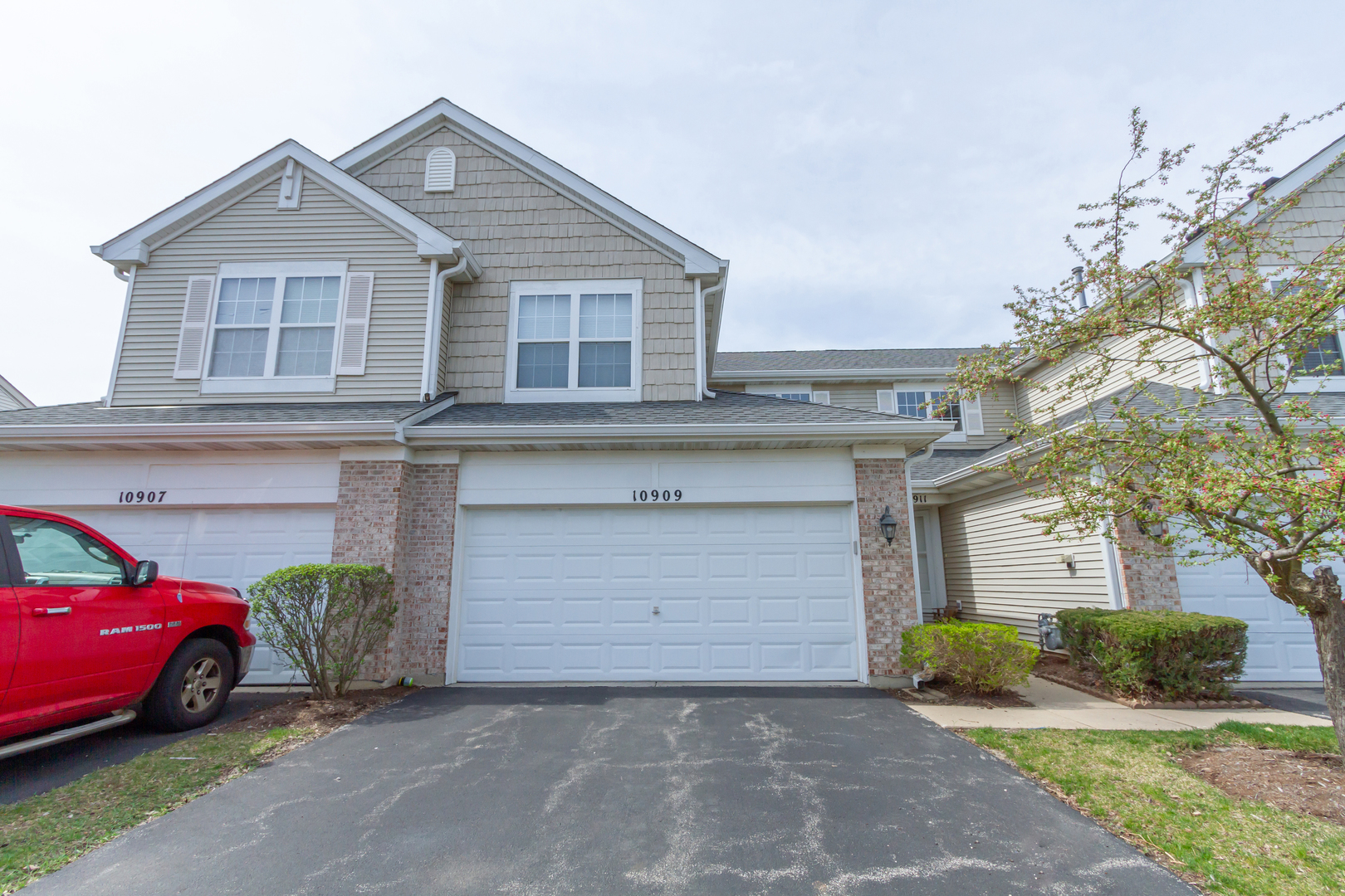 10909 Cape Cod Lane Huntley, IL 60142 - Photo 2 of 18 a front view of a house with a yard and garage