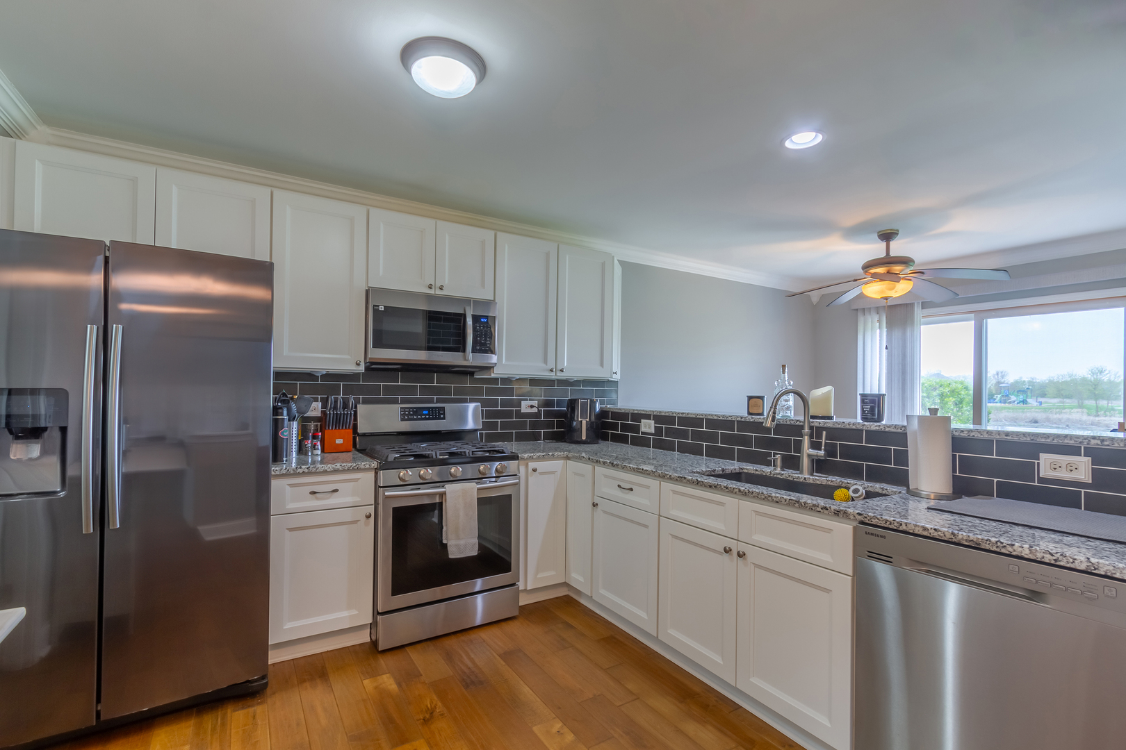 10909 Cape Cod Lane Huntley, IL 60142 - Photo 7 of 18 a kitchen with stainless steel appliances granite countertop a stove a sink and a refrigerator
