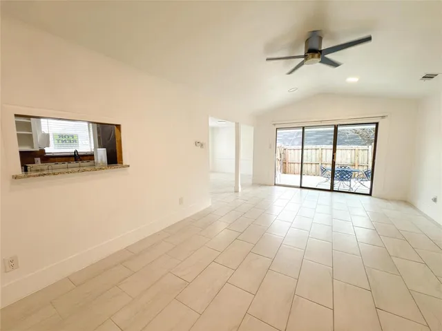 a view of an empty room with a fireplace and a window