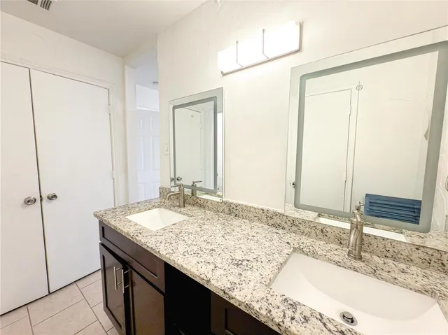 a bathroom with a granite countertop sink and a mirror