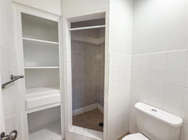 a bathroom with a toilet and a shower