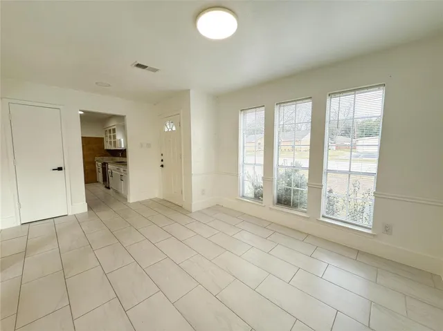 a view of an empty room with window and cabinet
