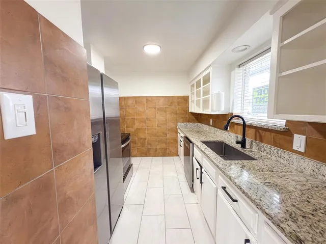 a bathroom with a granite countertop sink a toilet a mirror and bathtub