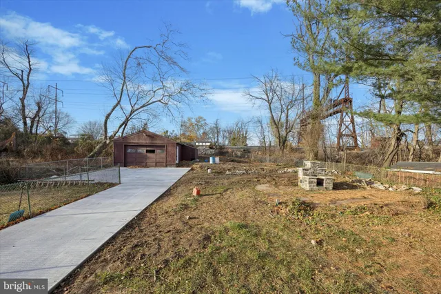 a backyard of a house with large trees and outdoor seating