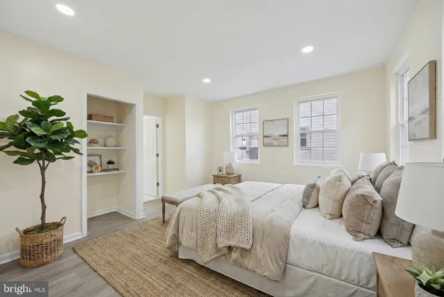 a bedroom with a large bed and a potted plant