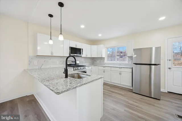 a kitchen with appliances cabinets a sink and a counter top space