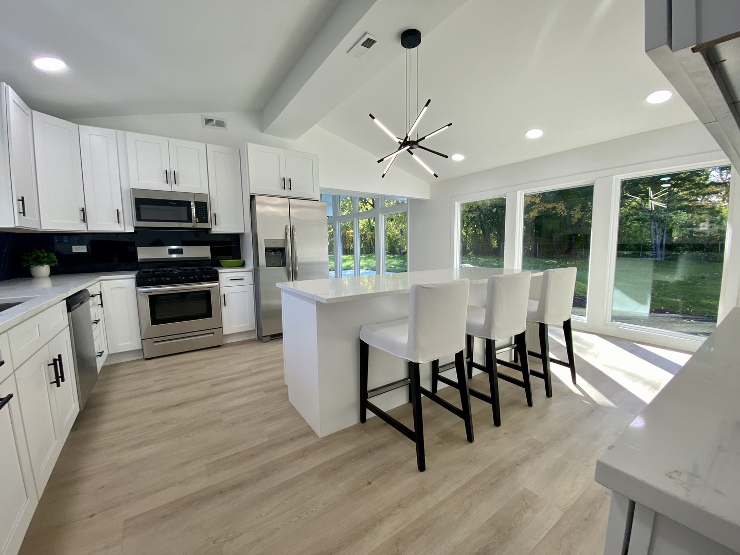 3131 Willow Road Northbrook, IL 60062 - Photo 12 of 23 a open kitchen with stainless steel appliances granite countertop a stove top oven a sink dishwasher a dining table and chairs with wooden floor