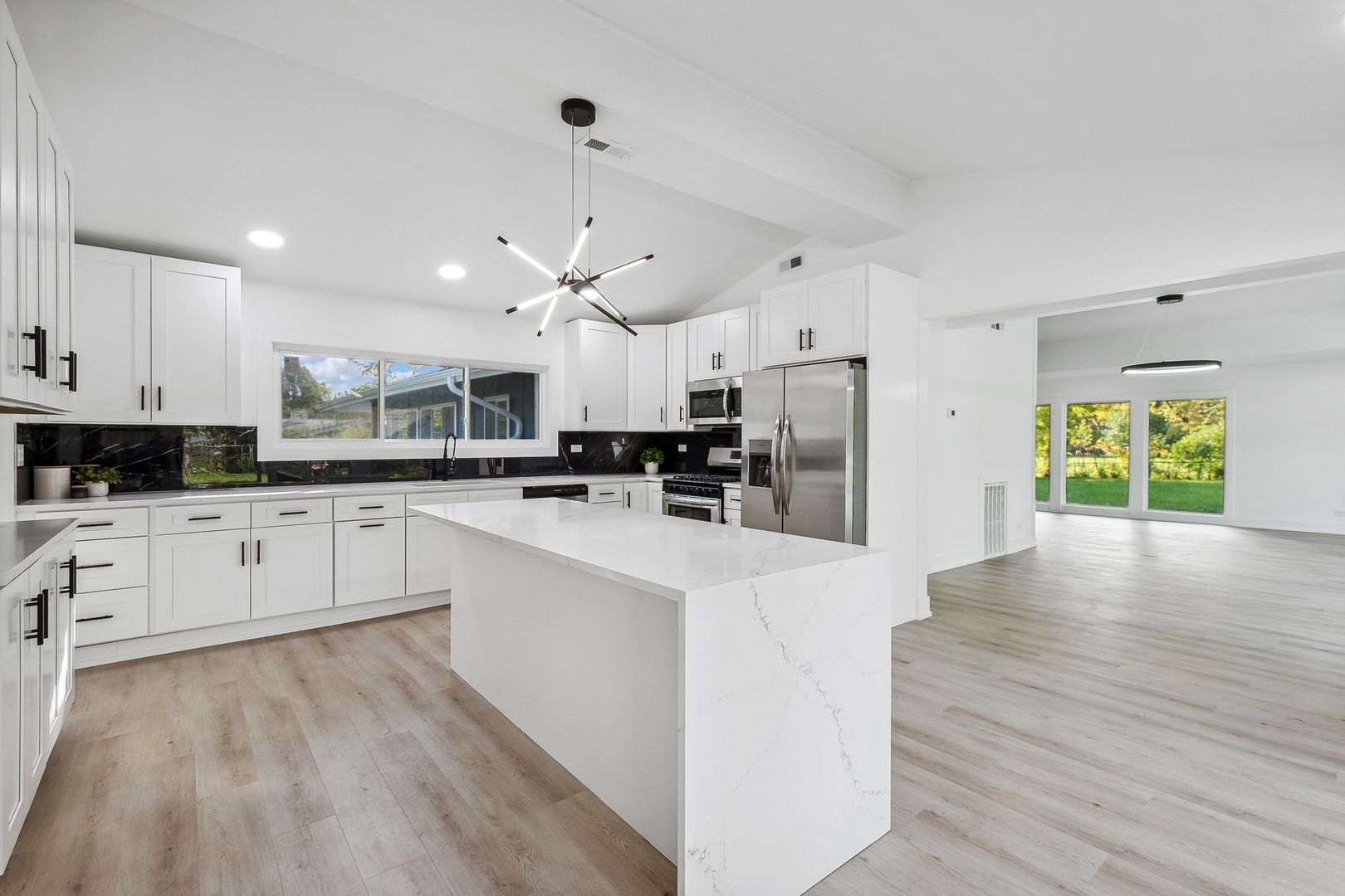 3131 Willow Road Northbrook, IL 60062 - Photo 9 of 23 a large white kitchen with stainless steel appliances granite countertop a stove and a refrigerator