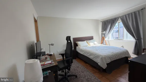 a bedroom with a bed a desk and chair with rug
