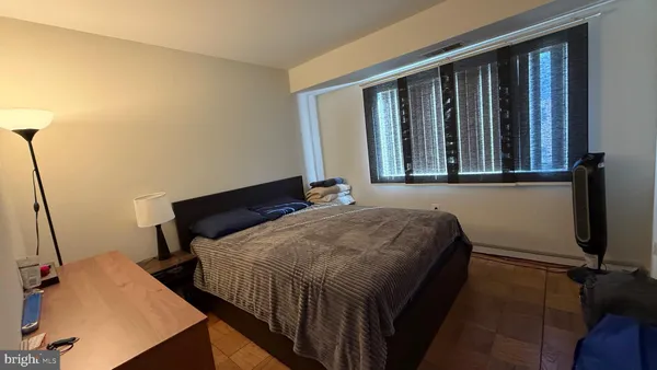 a bedroom with a bed window and mirror