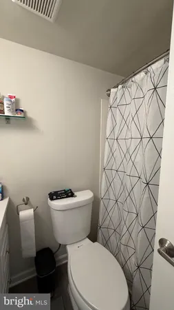 a white toilet sitting next to a white wall