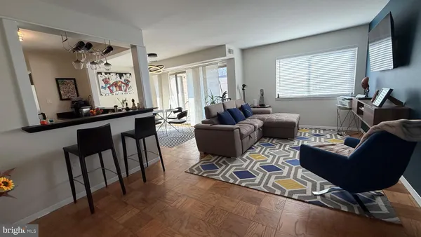 a living room with furniture a flat screen tv and a window
