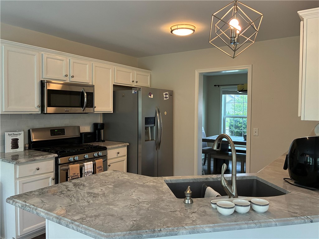18 Dona Lea Road Perinton, NY 14450 - Photo 7 of 29 The kitchen features stainless steel appliances and a breakfast bar for entertaining guests or hosting casual meals.
