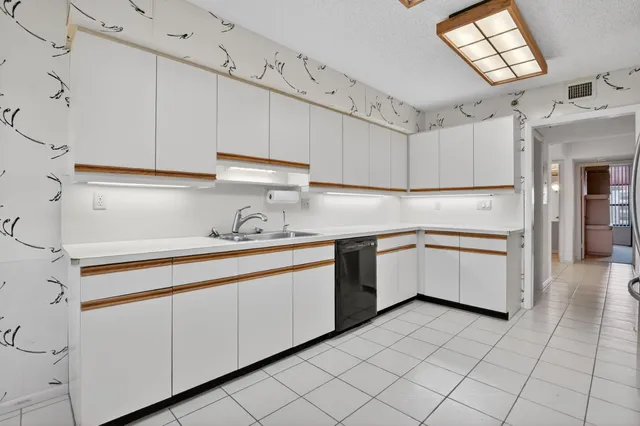a kitchen with white cabinets stainless steel appliances and a window