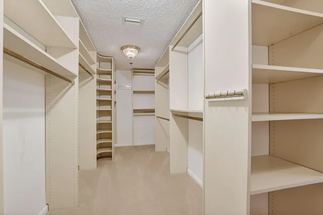 a view of walk in closet with empty racks