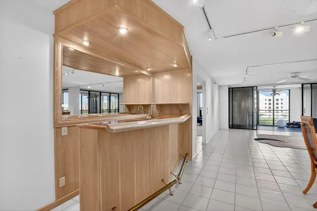 a living room with stainless steel appliances kitchen island granite countertop a sink and cabinets