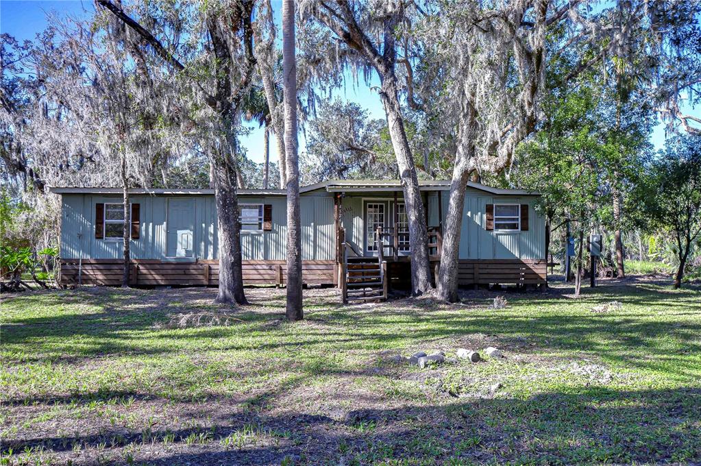 a view of a house with backyard and a tree