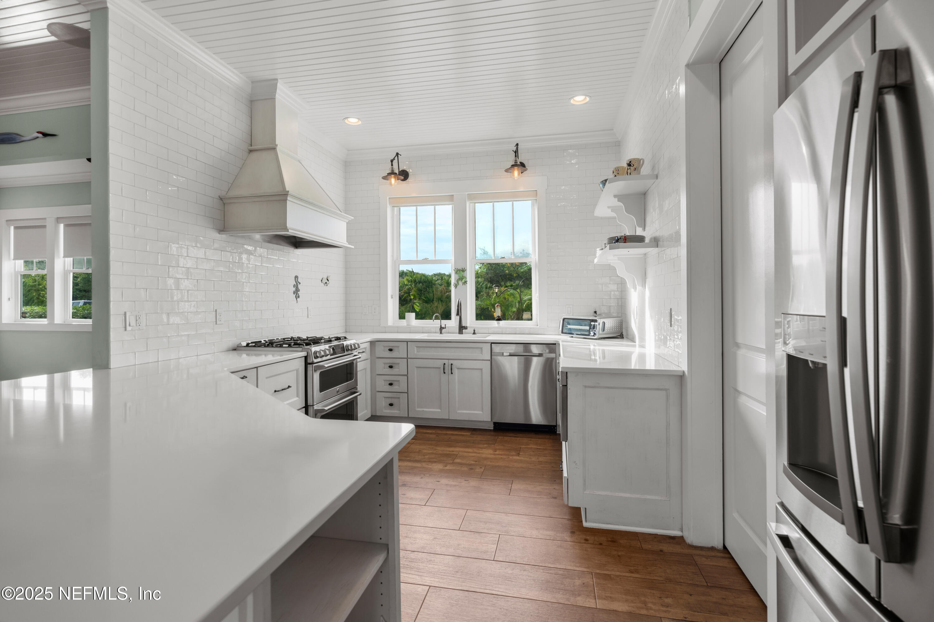 211 10th Street St. Augustine, FL 32080 - Photo 12 of 47 a kitchen with stainless steel appliances a refrigerator sink and cabinets