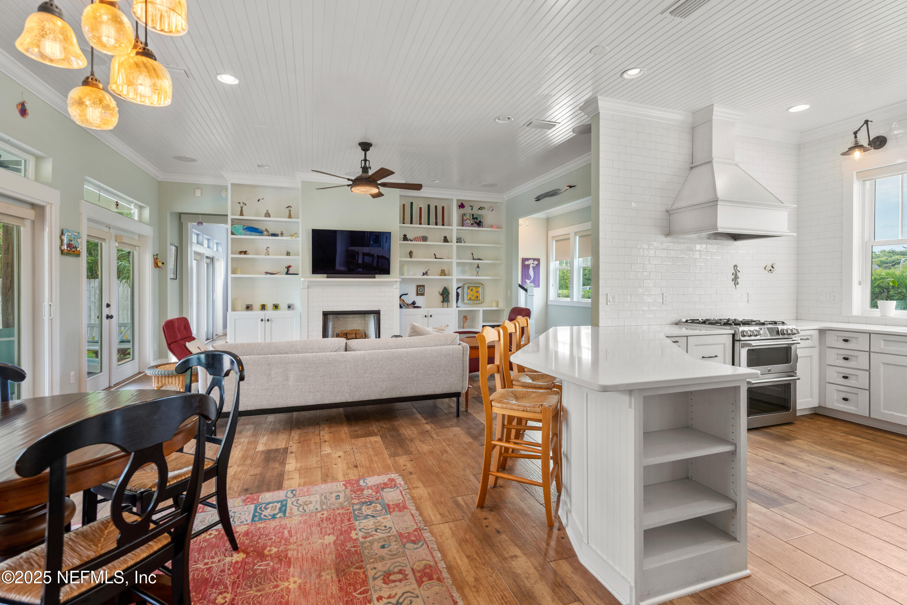 211 10th Street St. Augustine, FL 32080 - Photo 14 of 47 a living room with furniture a flat screen tv and kitchen view
