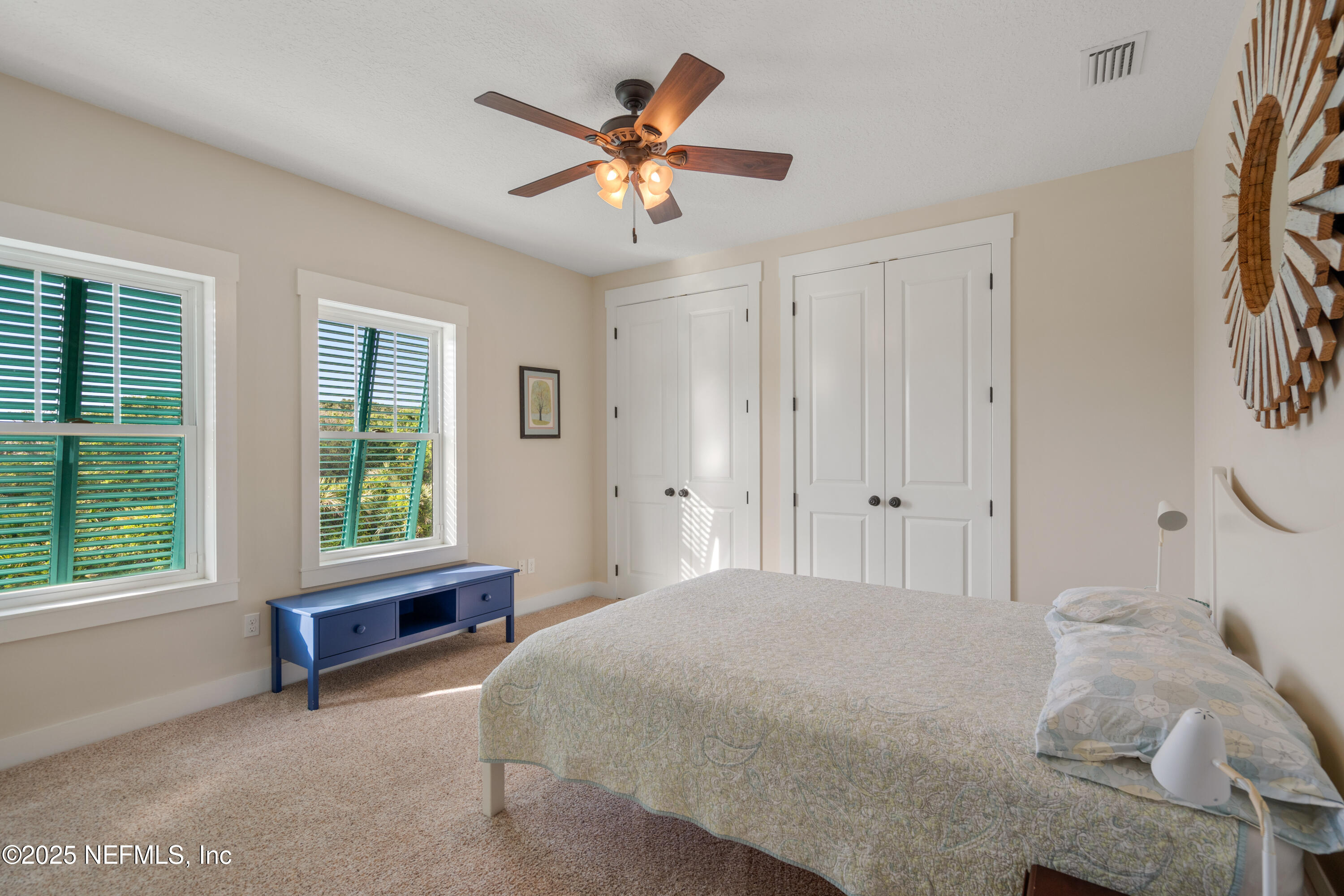 211 10th Street St. Augustine, FL 32080 - Photo 22 of 47 a spacious bedroom with a large bed and a chandelier