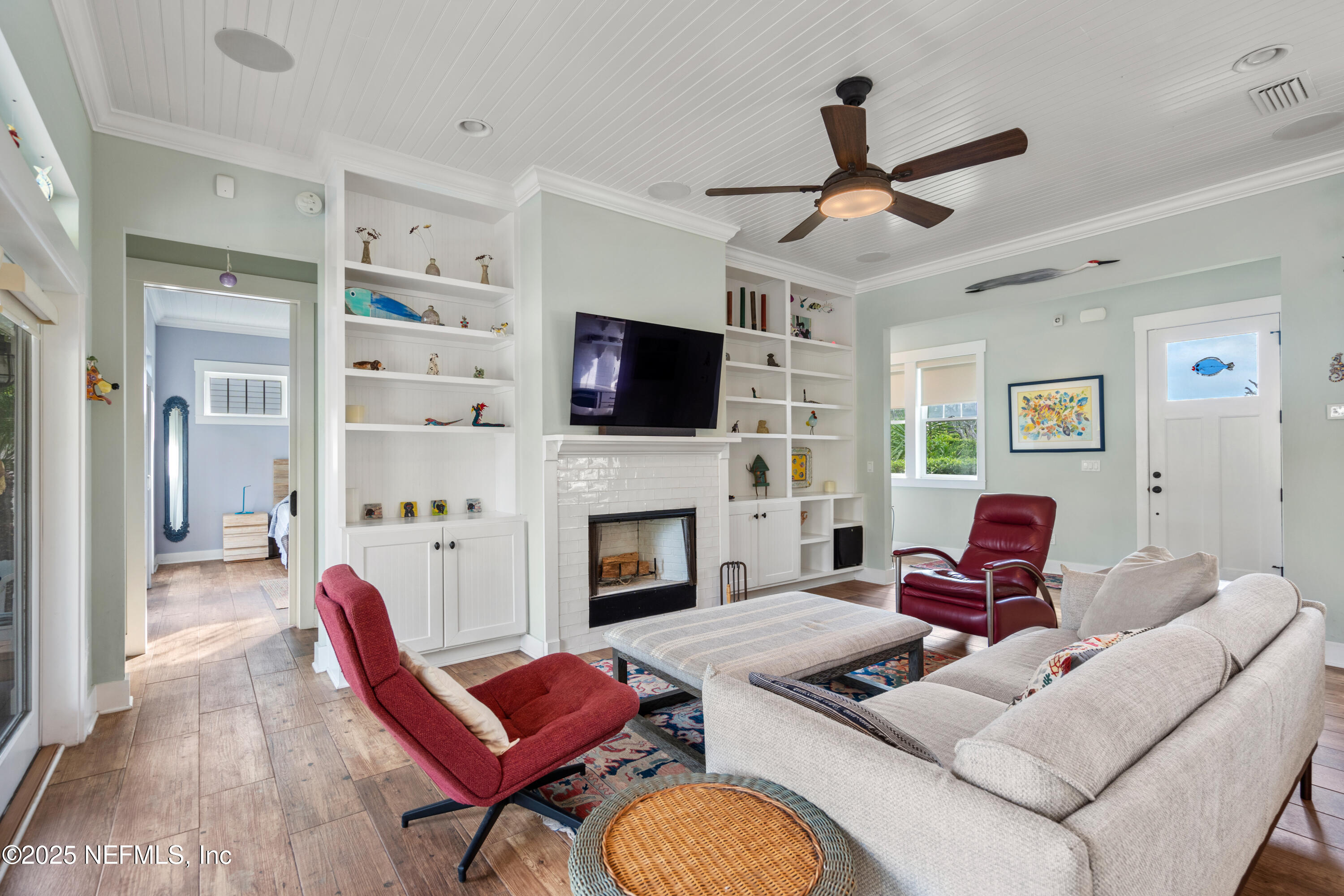 211 10th Street St. Augustine, FL 32080 - Photo 7 of 47 a living room with furniture a flat screen tv and a fireplace